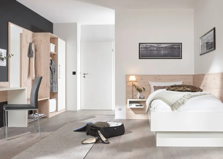 Helles Jugendzimmer mit Einzelbett, Kleiderschrank und Schreibtisch.